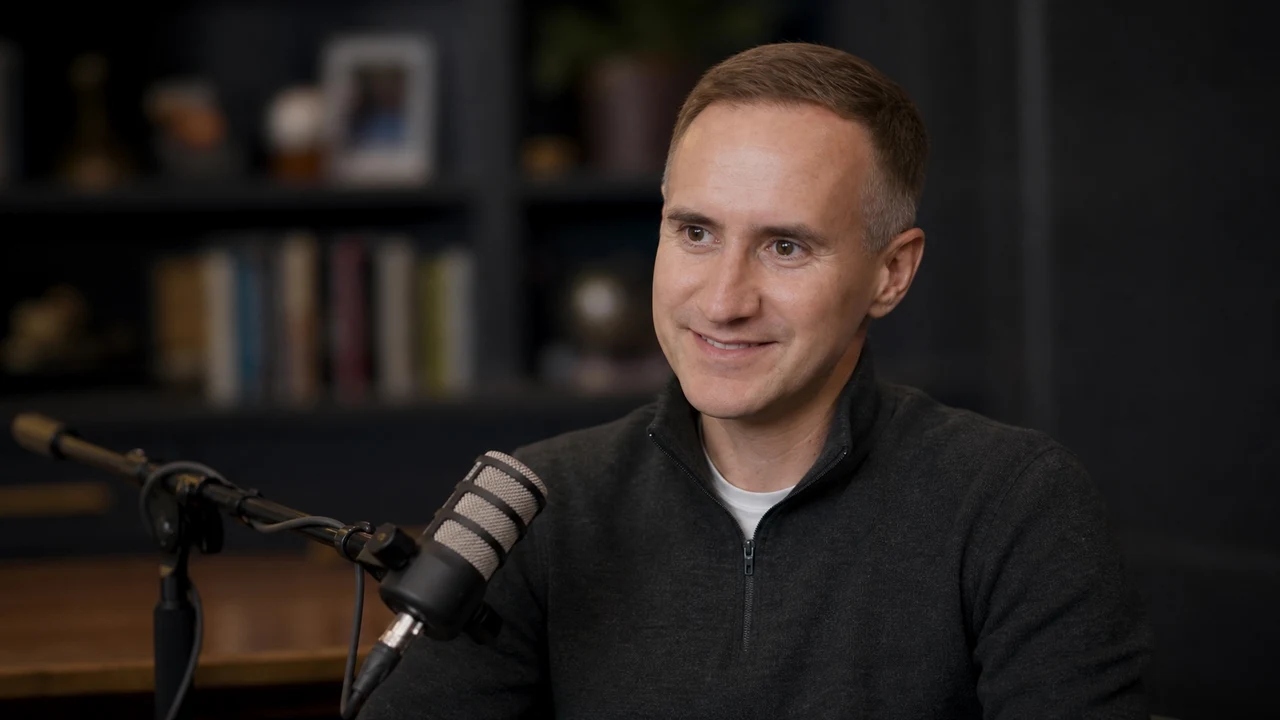 Morgan Housel speaking into a broadcast microphone during a podcast conversation
