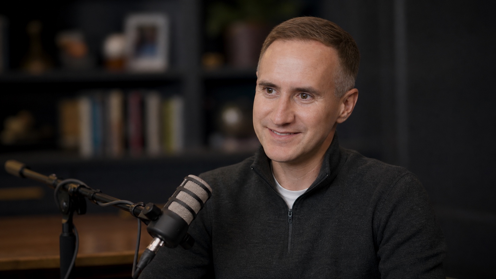 Morgan Housel speaking into a broadcast microphone during a podcast conversation